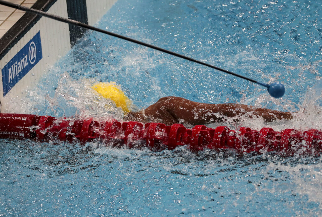 imagem de nadador com deficiência visual com o auxílio de um tapper, acessório permitido pelas regras da natação paralímpica