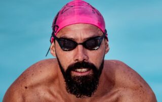 homem saindo da piscina, representando os melhores óculos de natação