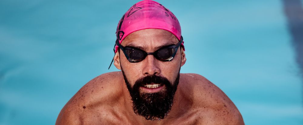 homem saindo da piscina, representando os melhores óculos de natação