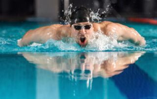homem nadando o estilo borboleta, demonstrando a eficiência dos educativos de natação
