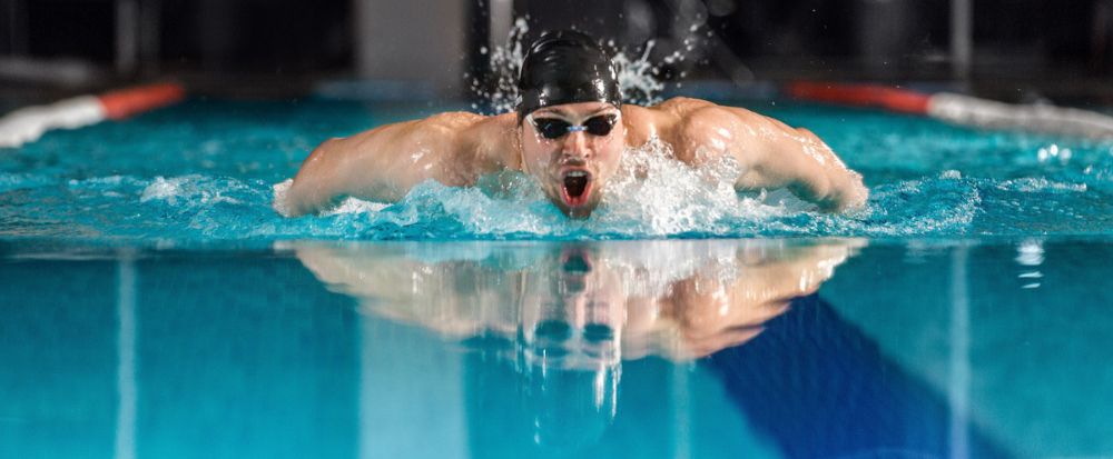 homem nadando o estilo borboleta, demonstrando a eficiência dos educativos de natação