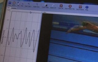 Imagem de computador em cima de mesa, com uma análise de biomecânica da natação