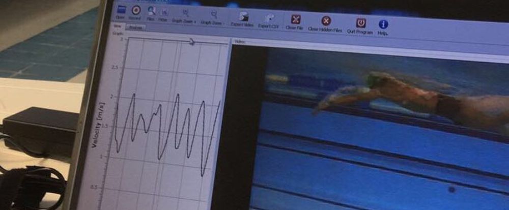 Imagem de computador em cima de mesa, com uma análise de biomecânica da natação