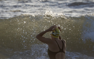 imagem de mulher nadadora enfrentando uma onda, o que representa projeto nadando com elas, que combate a violência da mulher no esporte